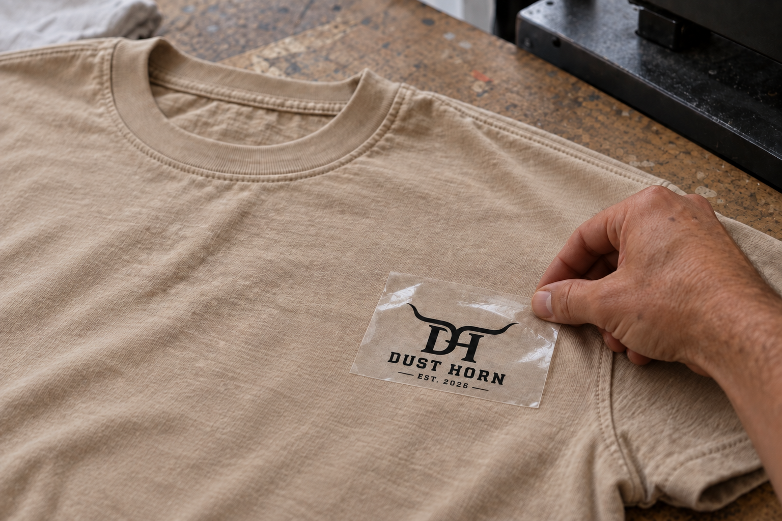 Pose d’un visuel DTF Dust Horn sur un t-shirt sable
